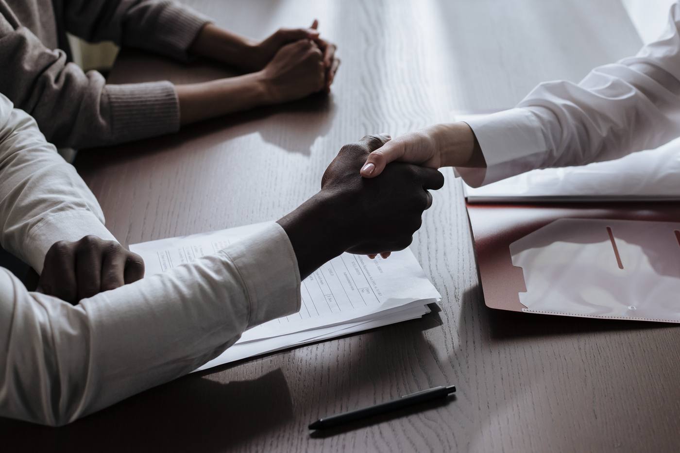 Poignée de main au-dessus d'un contrat, autour d'une table de réunion